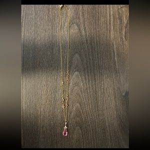 women’s gold necklace with pink gem